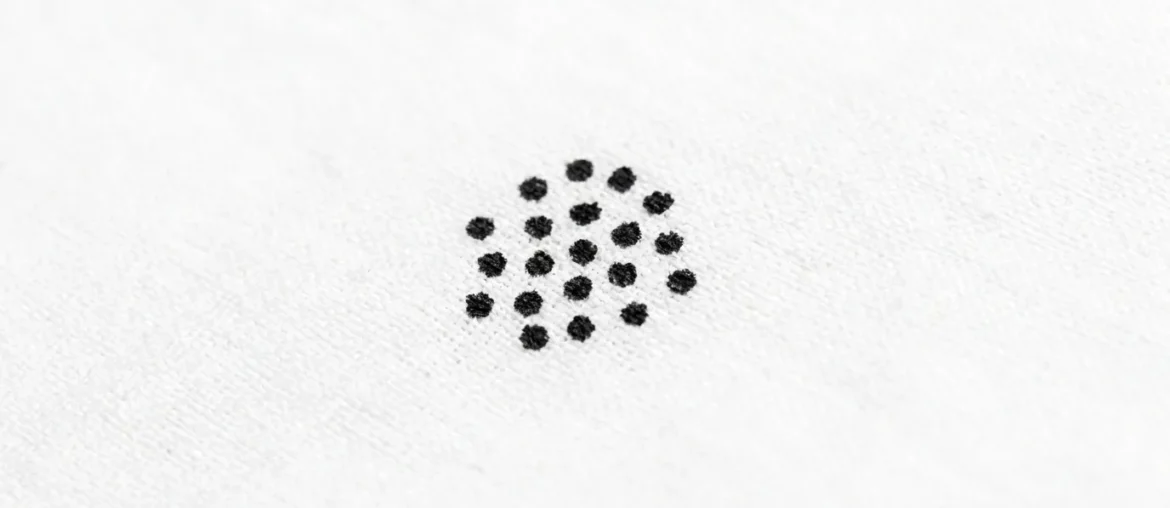 Petites taches noires de déjections de punaises de lit sur un drap blanc